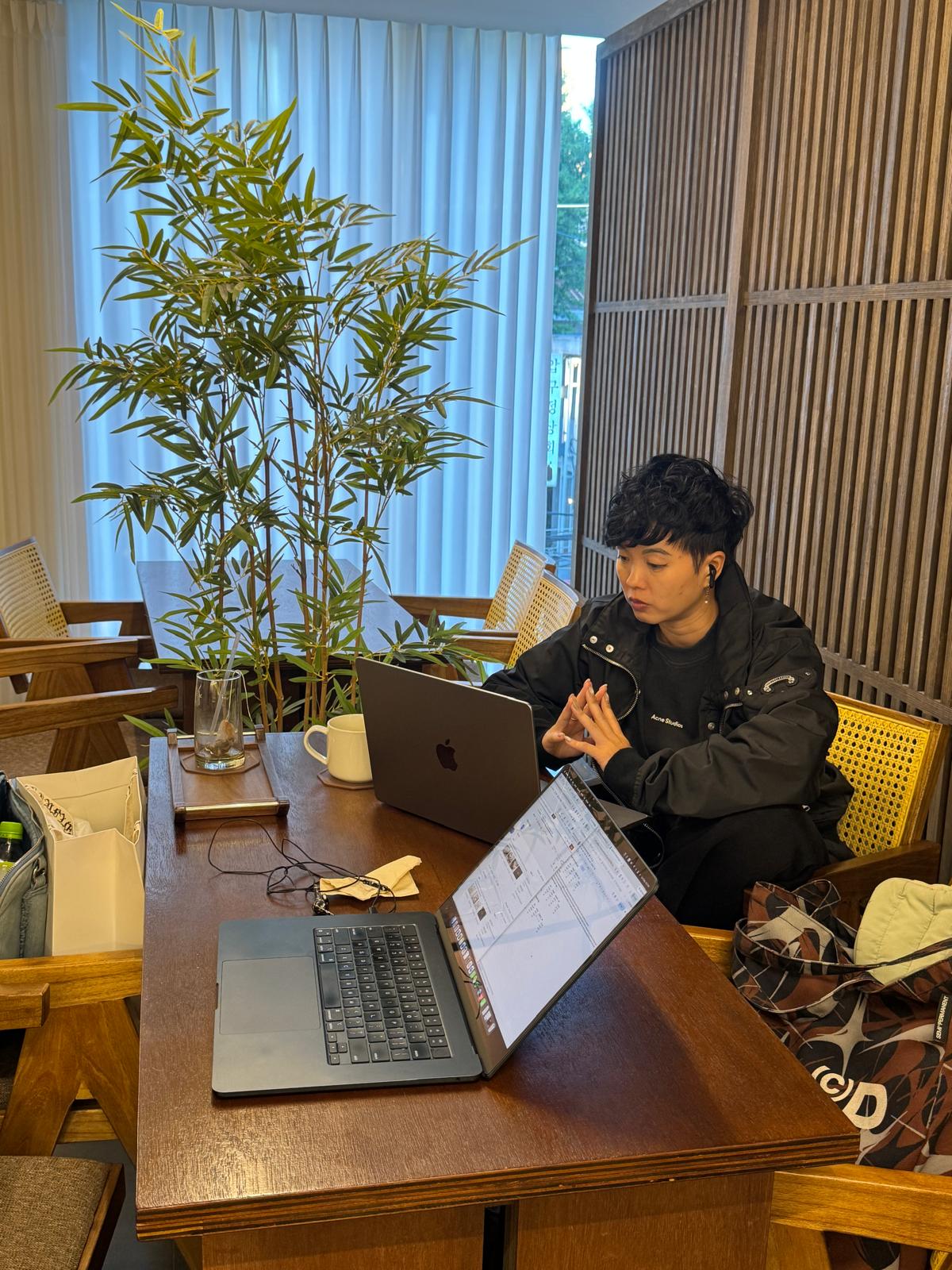 카페에서 노트북 두 대를 펼쳐놓고 일하는 Annie